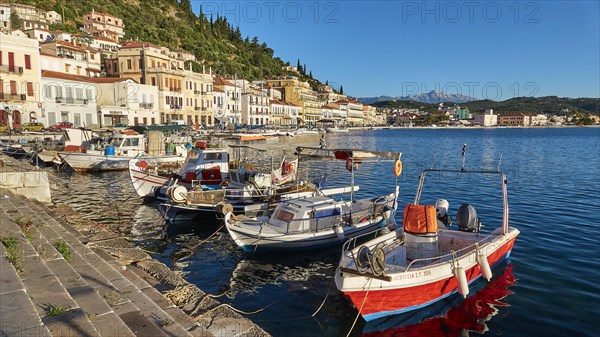 Small fishing boats at a sun-drenched Mediterranean harbour with mountains, Taygetos Mountains, Taygetos, Gythio, Mani, Peloponnese, Greece, Europe