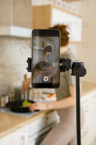 Food vlogger recording video in her kitchen, making step by step tutorial of a receipt