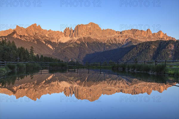 Mountains reflected in a small mountain lake, sunset, evening light, Wuhnleger, view of rose garden, Dolomites, South Tyrol, Italy, Europe