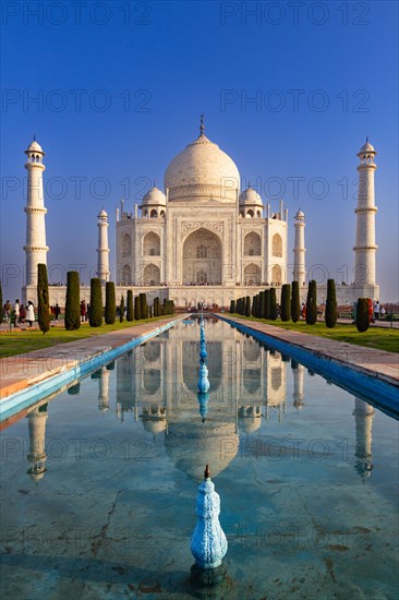 Symmetrical view of the Taj Mahal with its reflection in the water under a clear blue sky, Taj Mahal, Agra, India, Asia