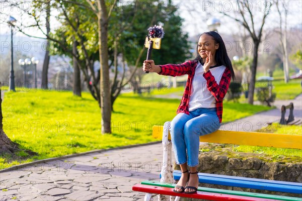 Horizontal photo with copy space of a happy african woman blogger is filming video blog on the street