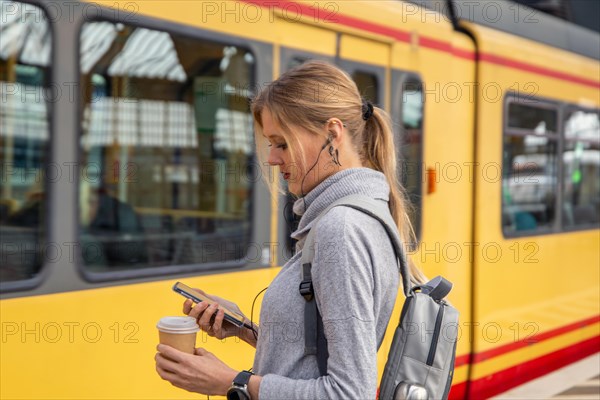 Close-up of a young woman in front of a train at the station