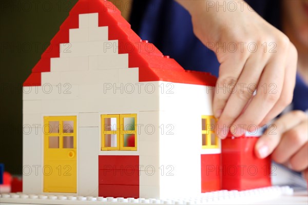 Boy builds a house with building blocks