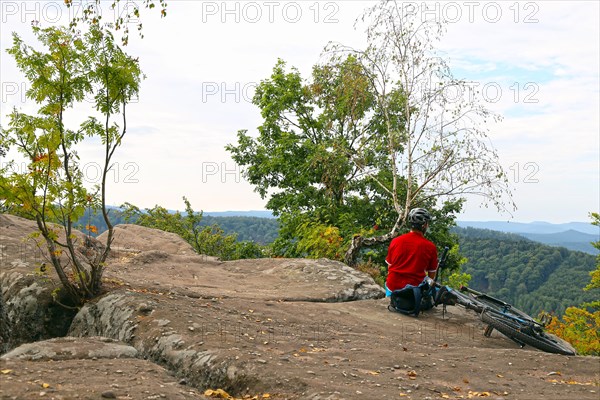 Mountain biker enjoys the view of the Palatinate Forest from the Drachenfels plateau