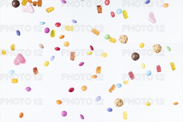 Colourful sweets fall against a white background