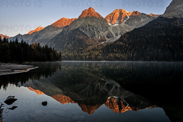Mountains reflected in lake at sunrise, autumn, Lake Antholz, South Tyrol, Italy, Europe