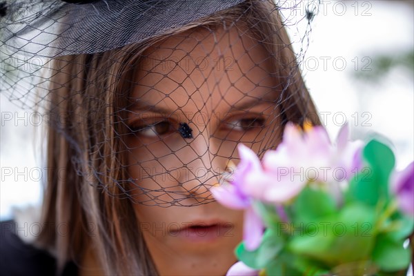 Close-up of a grieving young woman with a mourning veil (symbolic image)