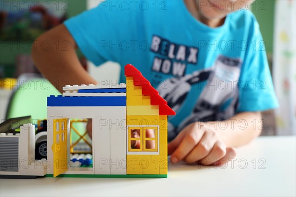 Boy builds a house with building blocks