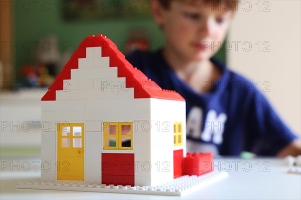 Symbolic image: Boy builds a house with building blocks