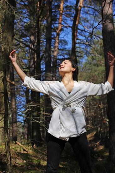 Young woman bathing in the forest (Shinrin Yoku), nature therapy from Japan