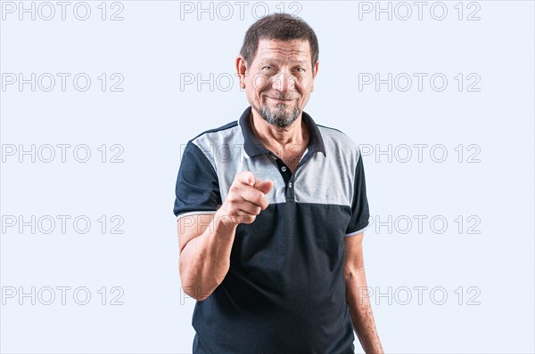 Smiling senior man pointing at camera isolated. Positive senior person pointing at camera with friendly expression