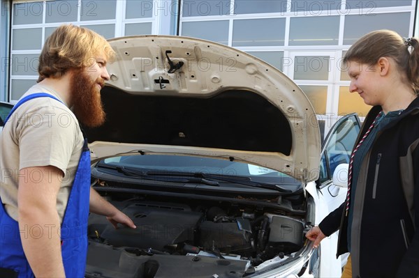 Symbolic image: Car mechatronics technician with customer in the garage