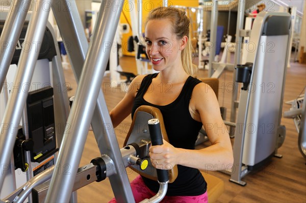 Young woman training on equipment in the gym