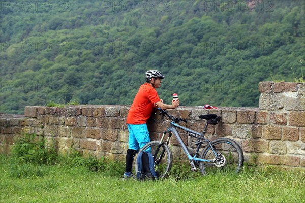 Mountain biker takes a break at the Wolfsburg above Neustadt an der Weinstrasse