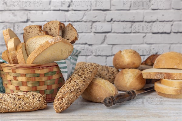 Various wholemeal and white breads in a bread basket on a country-style worktop