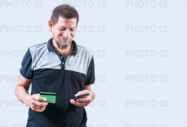 Smiling senior man holding credit card and smartphone isolated. isolated. Cheerful senior man shopping online holding credit card and smartphone
