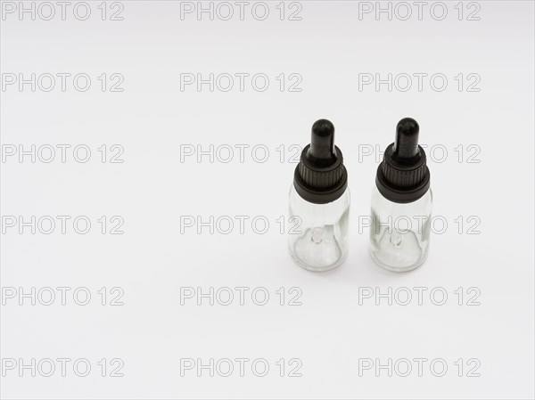 Two glass eye dropper bottles isolated on white background