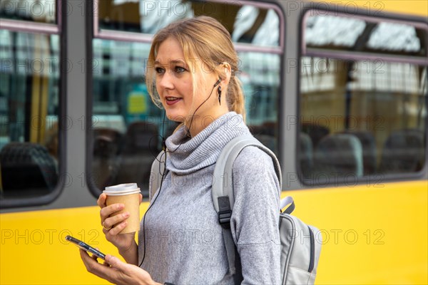 Close-up of a young woman in front of a train at the station