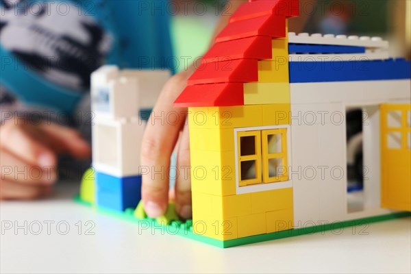 Boy builds a house with building blocks