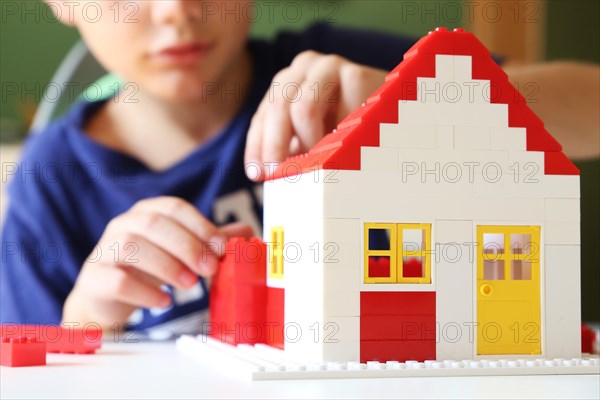 Boy builds a house with building blocks