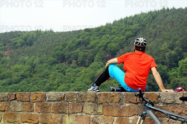 Mountain biker takes a break at the Wolfsburg above Neustadt an der Weinstrasse