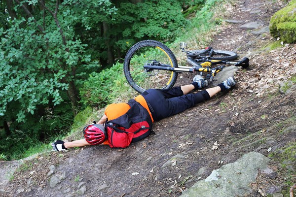 Injured mountain biker lying on the ground in an accident