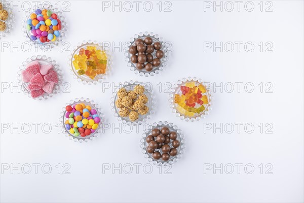 Sweets on small glass plates on a white background photographed from above