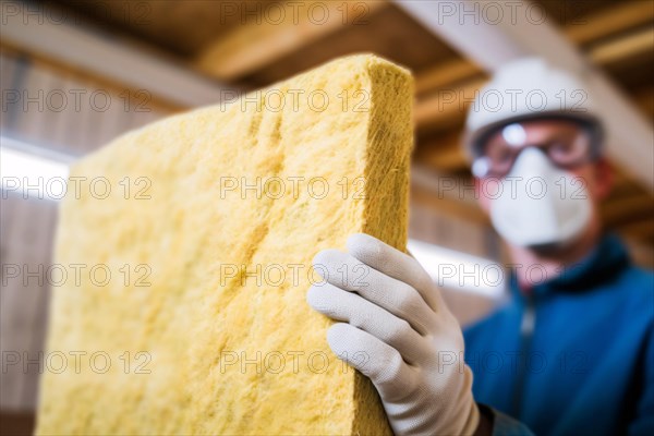Construction worker installing mineral wool filling used as isolation material in walls. KI generiert, generiert AI generated