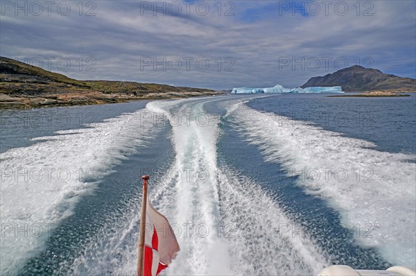 Boat passing icebergs in a fjord, Greenlandic flag, Qaqortoq, Greenland, Denmark, North America