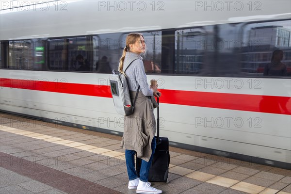 Young woman on the railway track while a train arrives