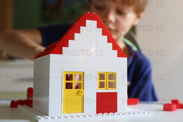 Symbolic image: Boy builds a house with building blocks