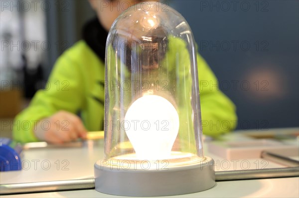 Child conducting a physics experiment with a simple circuit