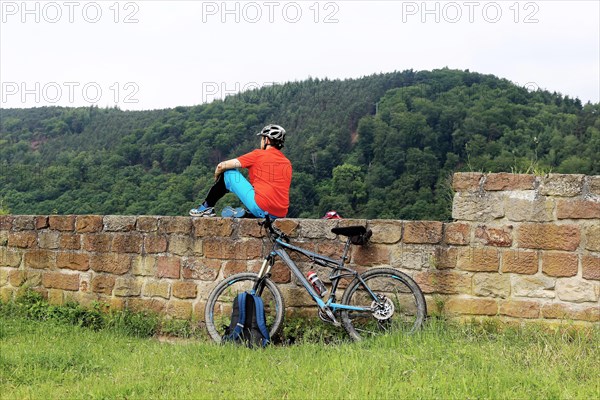 Mountain biker takes a break at the Wolfsburg above Neustadt an der Weinstrasse