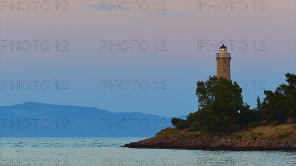 Silhouette of a lighthouse at dusk, a peaceful scene by the sea, Gythio, Mani, Peloponnese, Greece, Europe