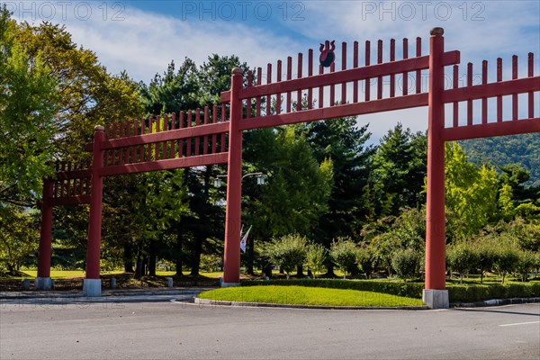 Large wooden Japanese style gate across four lane road in public park in South Korea