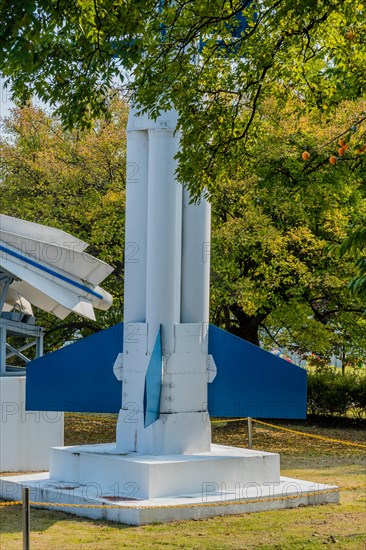 Lower portion of surface to air missiles behind tree branches in a public park