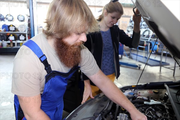 Symbolic image: Car mechatronics technician with customer in the garage