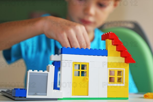 Boy builds a house with building blocks