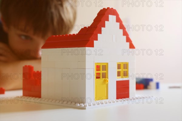 Boy builds a house with building blocks