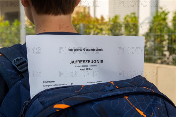 Symbolic image of report cards: Pupils at an integrated comprehensive school on their way home with their annual report cards