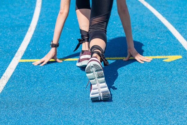 Athletics symbol: Young woman in front of the start of a race