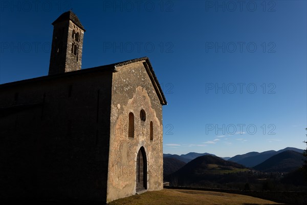 Beautiful Old Church with Mountain Range View with Sky and Sunlight in Malcantone, Miglieglia, Ticino, Switzerland, Europe