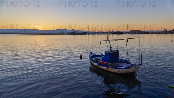 Lonely boat on the sea during a calm sunset, Gythio, Mani, Peloponnese, Greece, Europe