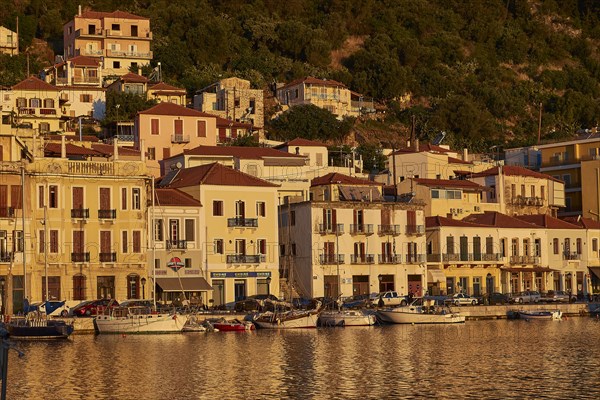 The harbour with sailing boats shines in the golden light of the sunset, Gythio, Mani, Peloponnese, Greece, Europe