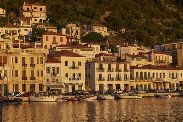 The harbour with sailing boats shines in the golden light of the sunset, Gythio, Mani, Peloponnese, Greece, Europe