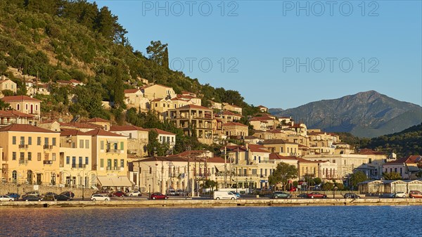 Traditional houses on a hill adjacent to calm waters in the morning light, Taygetos Mountains, Taygetos, Gythio, Mani, Peloponnese, Greece, Europe