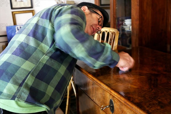 Furniture restorer polishes a table