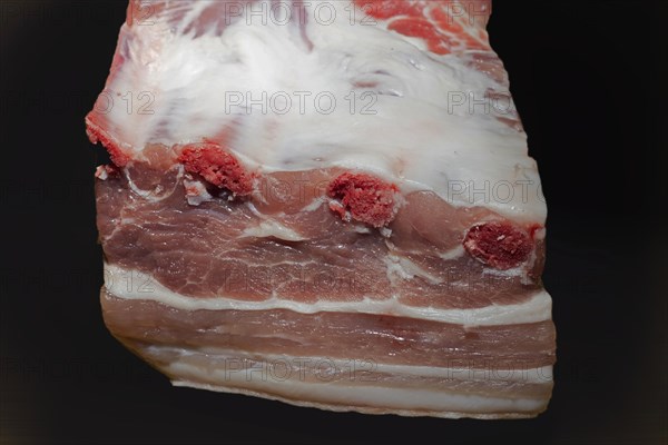 A piece of lean belly meat with bone, food photography with black background