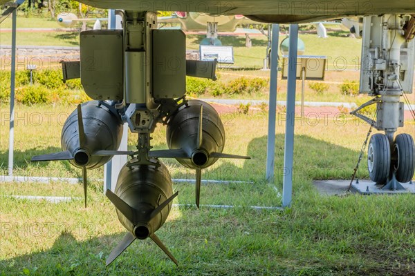 Rear view of battery of missiles mounted under wing of military jet aircraft on display in public park
