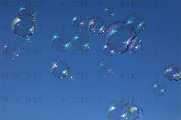 Soap bubbles multicoloured film of soapy water next to each other in front of a blue sky